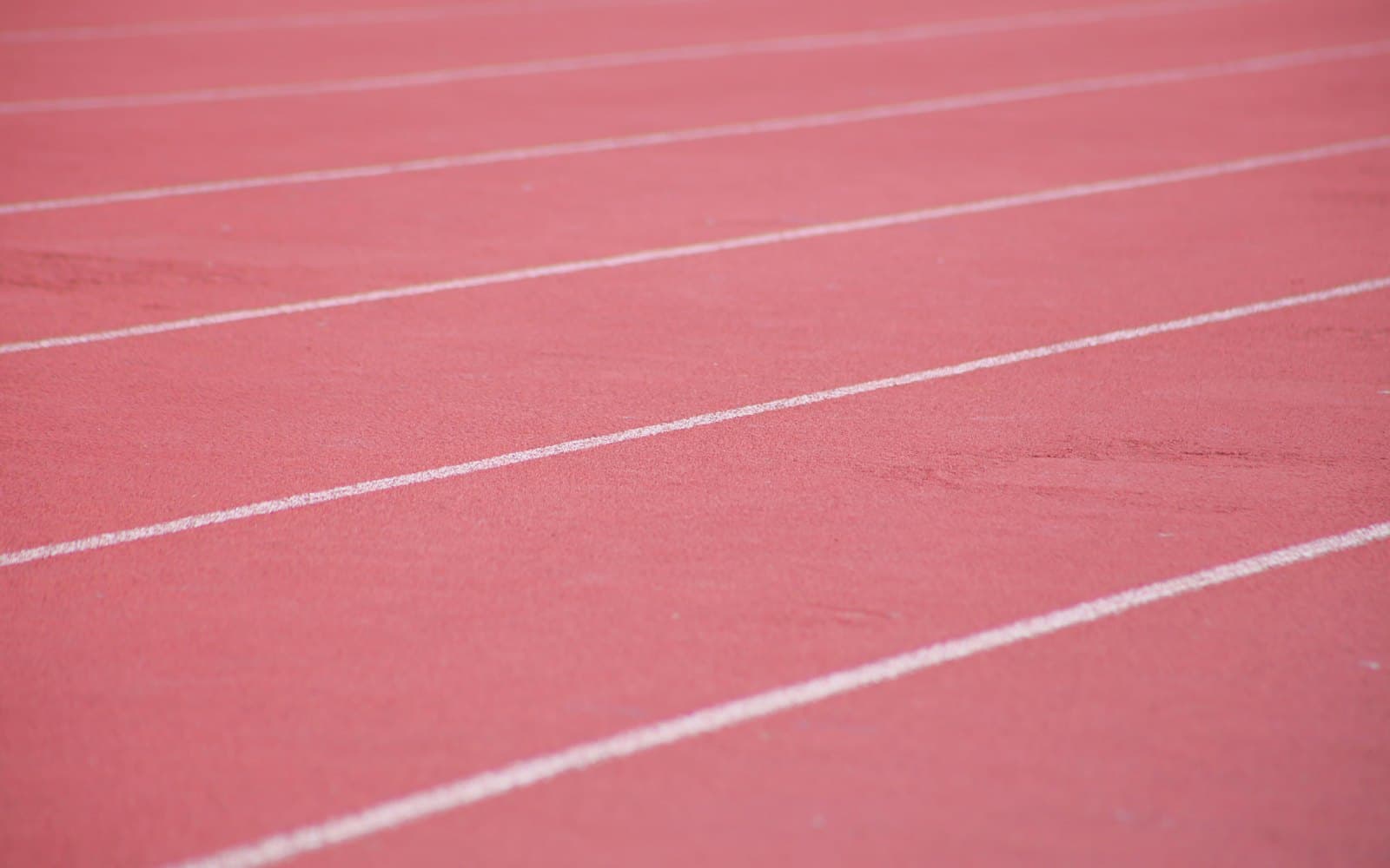 Lane markings painted on a red synthetic running track